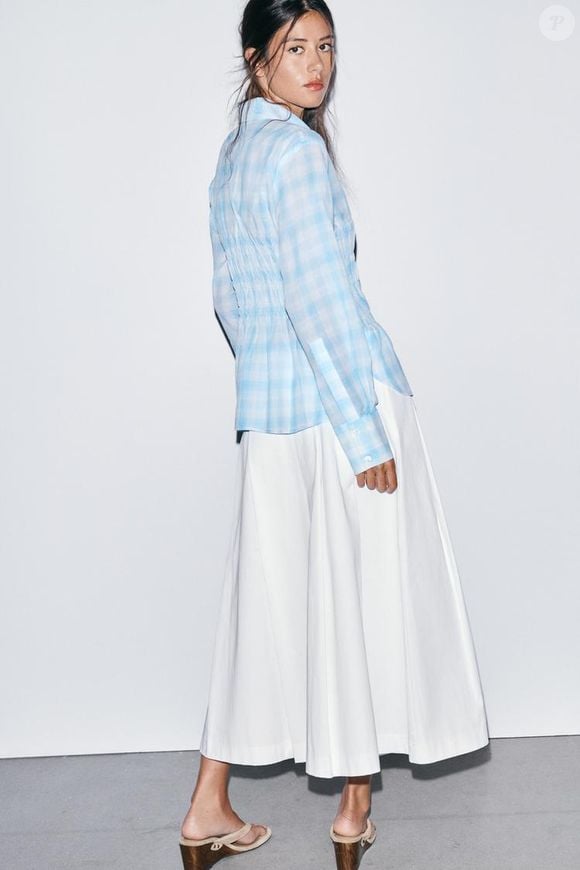 O design clean e as pregas estruturadas transformam a saia midi da Zara em uma escolha atemporal para mulheres elegantes