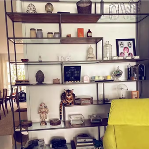 Sala de Grazi Massafera ainda conta com uma estante, que traz, além de objetos de decoração, livros, quadros, esculturas e álbuns de fotos