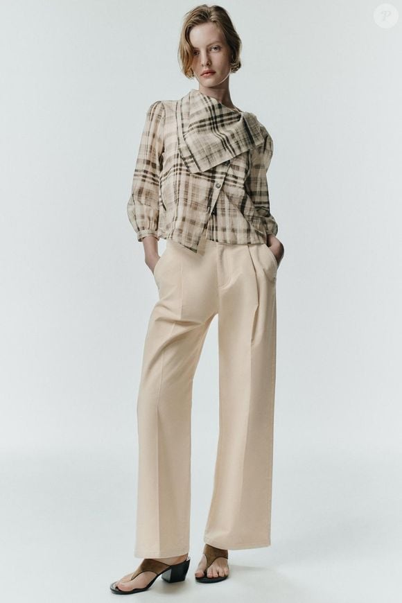 Entre os destaques da coleção da Zara está a Camisa Xadrez Lenço, uma peça cinza com gola tipo lenço, mangas abaixo do cotovelo e fechamento frontal cruzado com botões