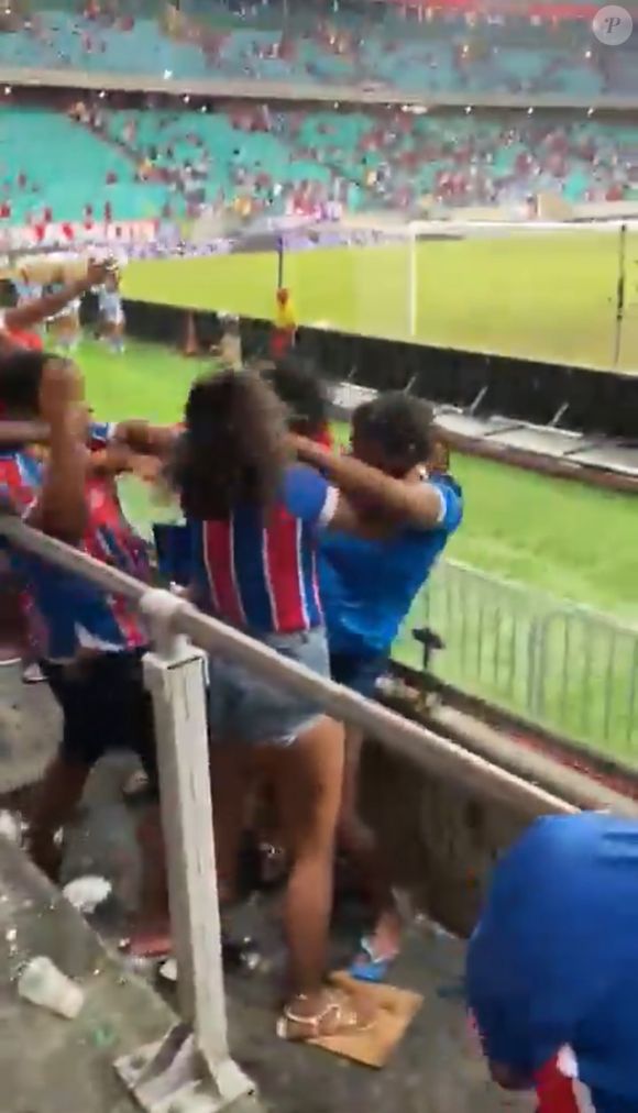 A confusão começa com duas torcedoras. A briga evolui, uma puxa o cabelo da outra e mais duas pessoas, um homem e uma mulher, se envolvem em uma pancadaria