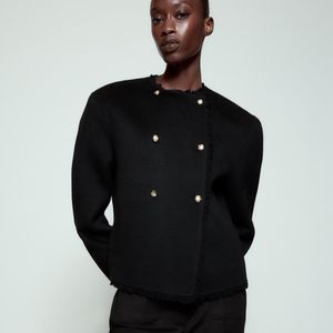 Segundo a descrição da Zara, o casaco preto da ZW Collection é confeccionado em tecido com mistura de lã e apresenta gola redonda, mangas amplas e bolsos frontais