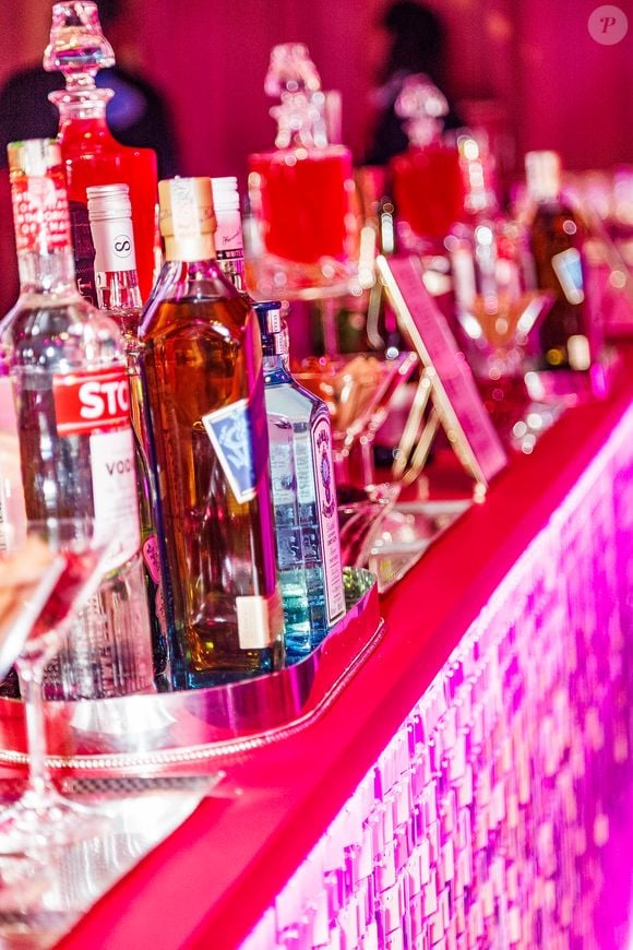 O bar da festa de 5 anos da WePink ganha iluminação rosa, painéis brilhantes e uma estante com perfumes da marca