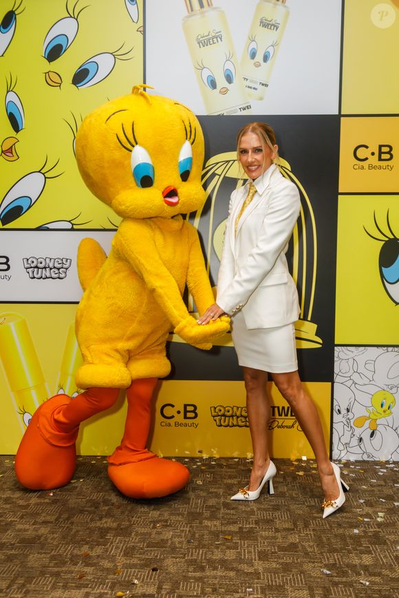 Deborah Secco aposta em look de alfaiataria branca com gravata dourada durante lançamento de collab de beleza inspirada no Piu-Piu, em São Paulo
