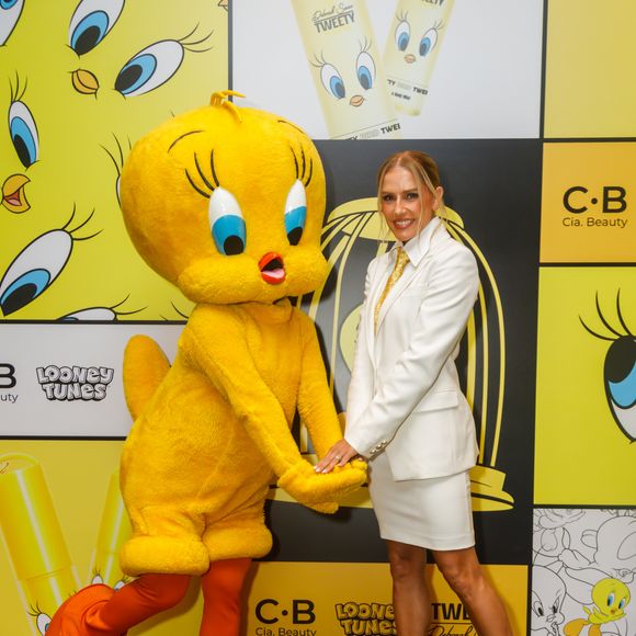 Deborah Secco aposta em look de alfaiataria branca com gravata dourada durante lançamento de collab de beleza inspirada no Piu-Piu, em São Paulo