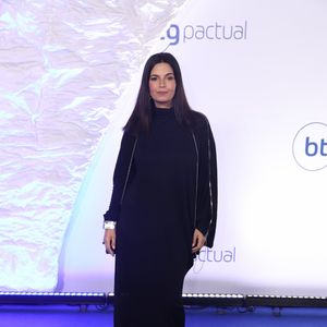 Isabelle Araújo: Vestido longo minimalista preto de gola alta e caimento reto e fluido. O grande destaque fica para o detalhe das mangas longas com zíper metálico aparente que se estende por todo o braço, complementado por um bracelete prateado largo por cima do punho