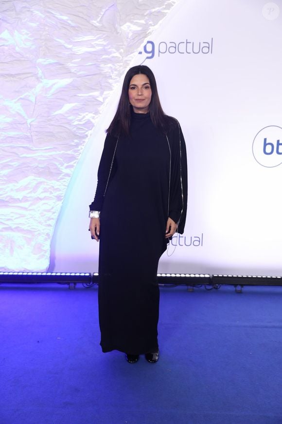 Isabelle Araújo: Vestido longo minimalista preto de gola alta e caimento reto e fluido. O grande destaque fica para o detalhe das mangas longas com zíper metálico aparente que se estende por todo o braço, complementado por um bracelete prateado largo por cima do punho
