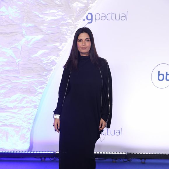 Isabelle Araújo: Vestido longo minimalista preto de gola alta e caimento reto e fluido. O grande destaque fica para o detalhe das mangas longas com zíper metálico aparente que se estende por todo o braço, complementado por um bracelete prateado largo por cima do punho