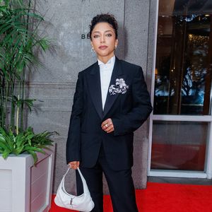 Alice Carvalho, de 'O Agente Secreto', entregou uma lição de power dressing ao cruzar o tapete vermelho com um conjunto de alfaiataria preta de corte impecável! O visual subverte o tradicional smoking com uma pegada andrógina e luxuosa: o blazer estruturado traz um maxi broche floral em prata e cristais na lapela, que serve como a principal joia do look. Por baixo, uma camisa branca de gola alta rígida e fechada evoca um estilo vitoriano moderno. Para quebrar a sobriedade, ela escolheu uma bolsa de ombro branca de couro (estilo Jackie) e sapatos de bico quadrado com fivelas metálicas, arrematando a produção com um penteado preso que destaca seus traços marcantes!