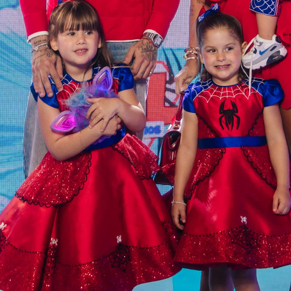 Maria Flor apareceu na comemoração usando um vestido vermelho rodado, com detalhes cintilantes e elementos azuis na gola e nas mangas enquanto o visual de Maria Flor foi finalizado com um laço azul no cabelo, mantendo a combinação de cores da decoração da festa
