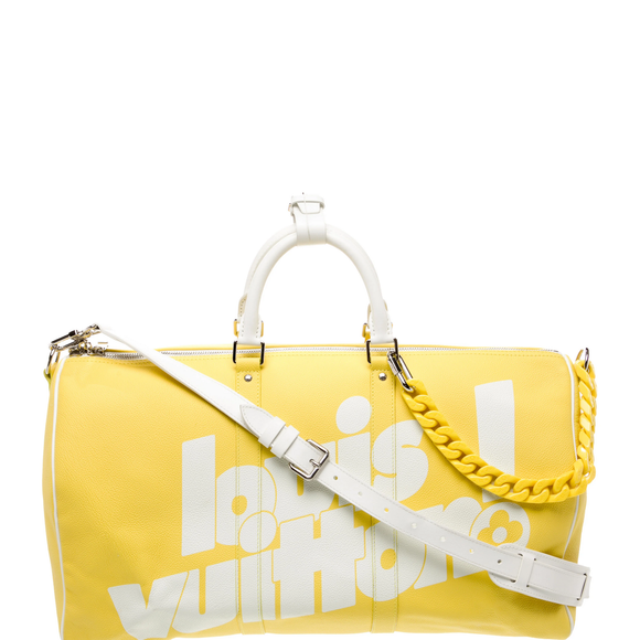 O camisa 10 também optou por uma chamativa Keepall Bandoulière 50 em couro amarelo e branco da Louis Vuitton, acompanhada por um divertido chaveiro que parece ser um dinossauro verde preso à alça