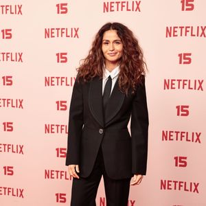 Nanda Costa: veste um fato preto de inspiração tuxedo com lapela em cetim, camisa branca, gravata preta fina e sapatos estilo mocassim com fivela dourada
