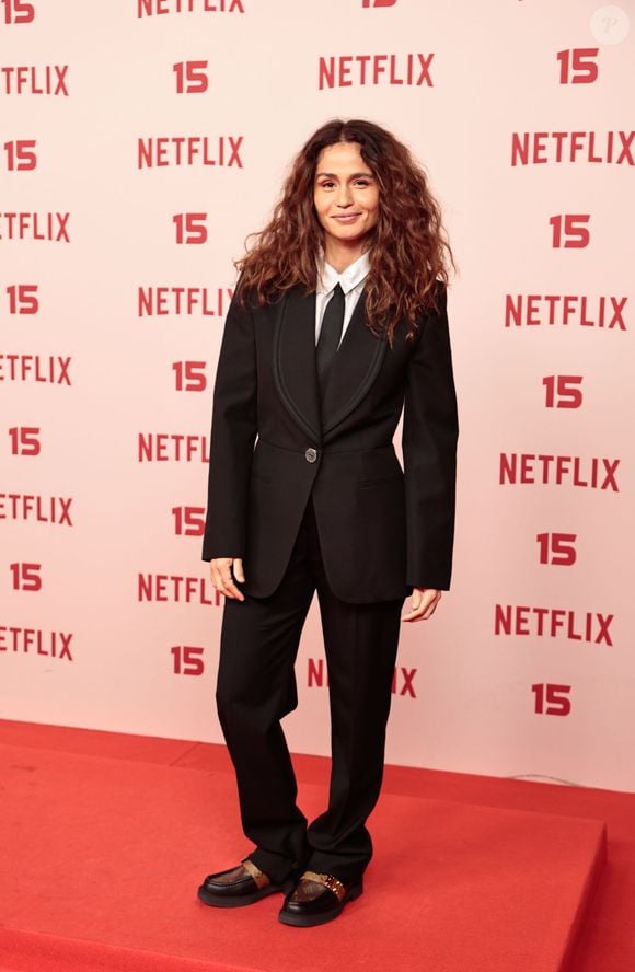 Nanda Costa: veste um fato preto de inspiração tuxedo com lapela em cetim, camisa branca, gravata preta fina e sapatos estilo mocassim com fivela dourada