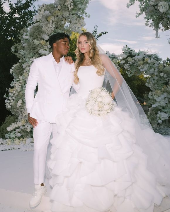 Para o penteado, Gabriely optou por deixar os fios soltos, com ondas suaves e bem definidas, que emolduravam seu rosto de forma natural. O cabelo dividido ao meio, combinado com a maquiagem suave - em tons neutros e com destaque para os cílios marcantes e lábios rosados - reforçou o ar de delicadeza e frescor da noiva.