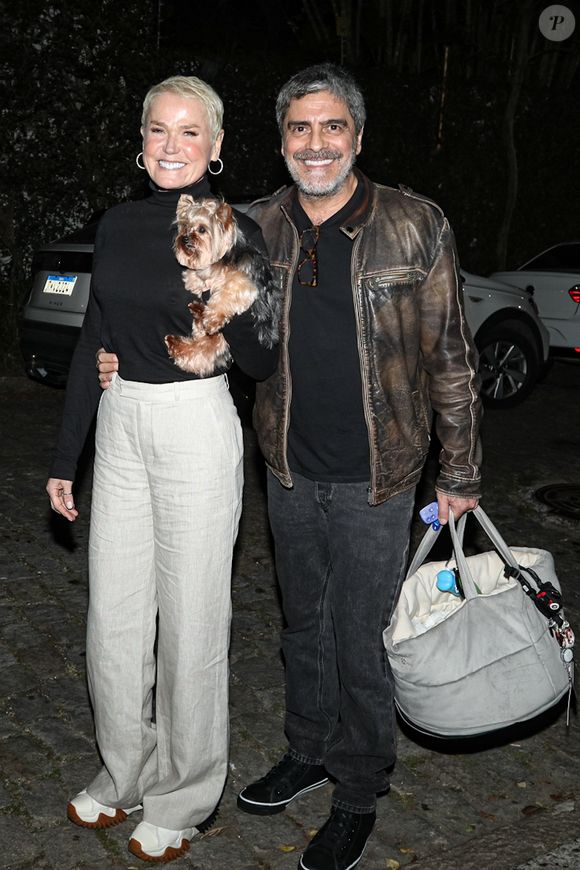 Xuxa foi outra convidada da festa de Luciano Huck e escolheu look preto e branco; seu marido, Junno Andrade também apostou em jaqueta de couro
