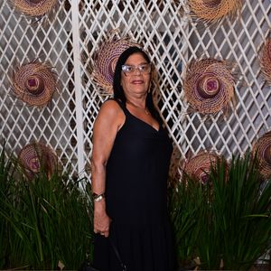 Dona Delma: exibiu elegância clássica em um vestido longo preto de alças grossas e decote em V, caracterizado por um leve babado na barra texturizada. A produção foi complementada por uma bolsa de ombro de couro preta estruturada, óculos de grau com armação transparente e sandálias abertas escuras