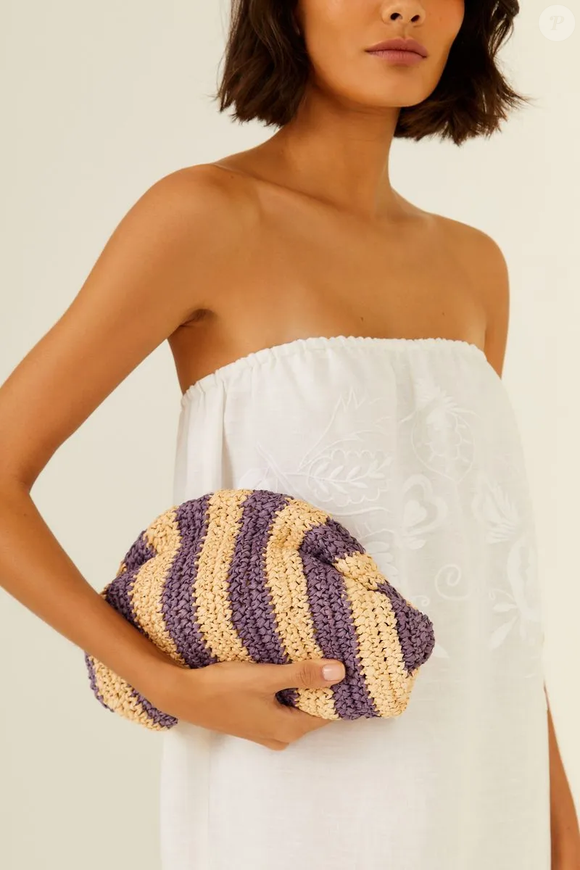 Feita em ráfia, a clutch carrega um charme natural que dialoga perfeitamente com looks frescos e descomplicados, sem abrir mão da sofisticação.