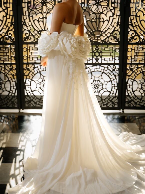 Para o ensaio pré-wedding, Emilly Araújo escolheu um vestido de inspiração romântica e dramática, com modelagem sereia e capa de musseline de seda coberta por flores artesanais