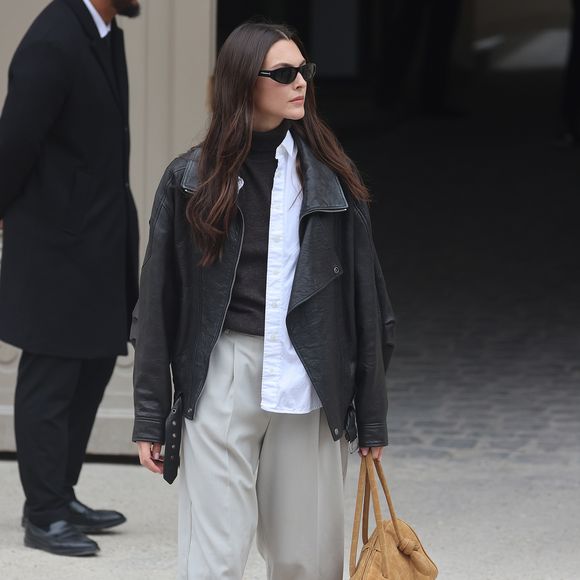 Já Vittoria Ceretti transformou a alfaiataria em algo descomplicado ao usar sobreposição de gola alta, camisa, jaqueta de couro e Speedcat bege