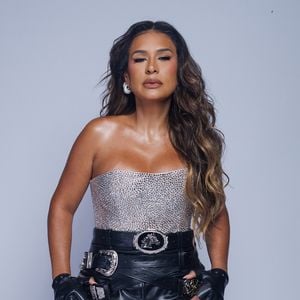 Simone Mendes completou o look com blusa sem alças prateada e bastante brilhosa, além de um cinto preto com fivela metálica