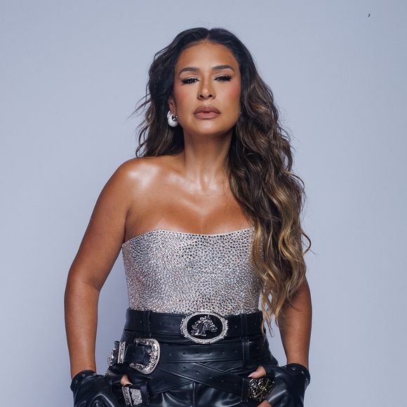 Simone Mendes completou o look com blusa sem alças prateada e bastante brilhosa, além de um cinto preto com fivela metálica