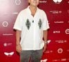 Marcos Palmeira escolheu uma camisa branca de mangas curtas com bordados de folhagens, combinada a uma calça cinza e tênis em tons de bege e preto