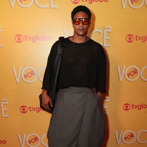 Humberto Morais exala uma proposta urbana com blusa preta de trama vazada e mangas compridas combinada a uma saia-calça ou calça envelope cinza-escuro de caimento volumoso. Nos acessórios, destacam-se os óculos de sol de lentes alaranjadas, bolsa tiracolo preta e sapatos de couro marrom