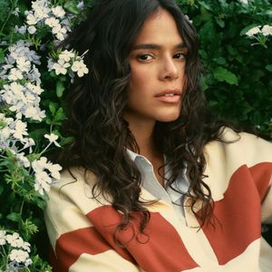 Bruna posa com suéter listrado e olhar sereno, reforçando o tom intimista da ação publicitária