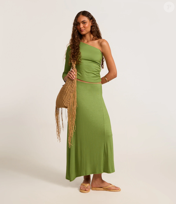 A saia longa midi em ribana com barra assimétrica verde, da Renner, é uma alternativa para criar um look coordenado com o New Balance ABZORB 2000, reforçando a tendência dos tons de verde na produção
