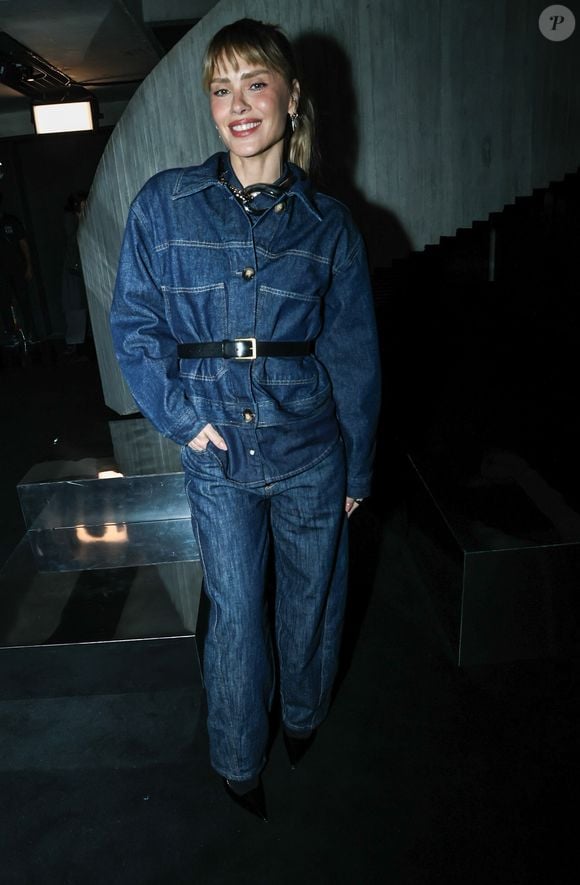Carolina Dieckmmann optou por um visual all-denim com um conjunto de lavagem escura. A jaqueta, de modelagem ampla, foi ajustada na cintura por um cinto de couro preto com fivela dourada, combinando com calças jeans de corte reto e sapatos de bico fino pretos