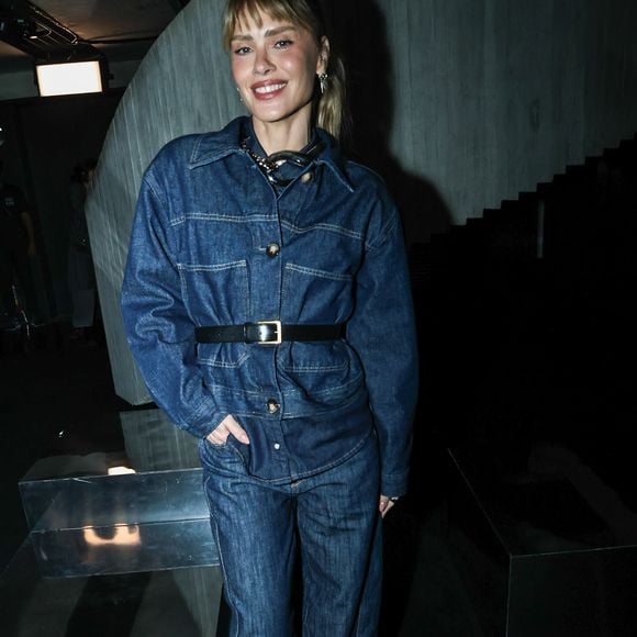 Carolina Dieckmmann optou por um visual all-denim com um conjunto de lavagem escura. A jaqueta, de modelagem ampla, foi ajustada na cintura por um cinto de couro preto com fivela dourada, combinando com calças jeans de corte reto e sapatos de bico fino pretos