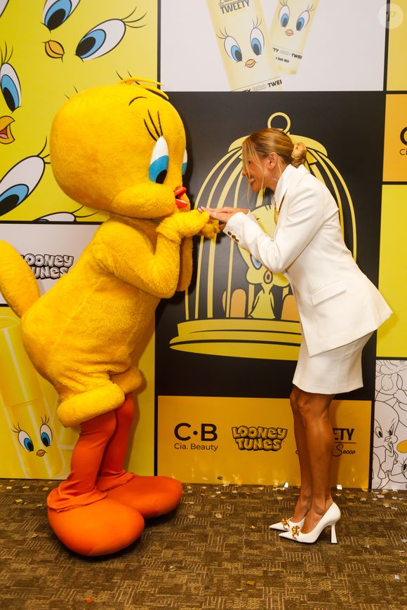 Atriz surge elegante com blazer estruturado e saia lápis em evento da Cia. Beauty com tema do personagem Piu-Piu