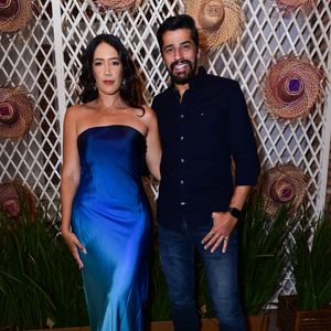 Alberto Cowboy e Priscilla Monroy: o ex-BBB combinou a informalidade da calça jeans escura com uma camisa social azul-marinho de botões e botas pretas de bico quadrado. Sua acompanhante usou um vestido midi tomara que caia em cetim fluido com efeito degradê que transiciona do azul-royal para o turquesa, finalizado com sandálias de strass
