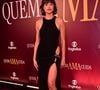 Agatha Moreira apostou em um longo minimalista de modelagem ajustada e decote fechado estilo frente-única, que ganha impacto através de uma fenda profunda e um audacioso recorte lateral na altura do quadril, unidos por um broche prateado orgânico que pontua a silhueta