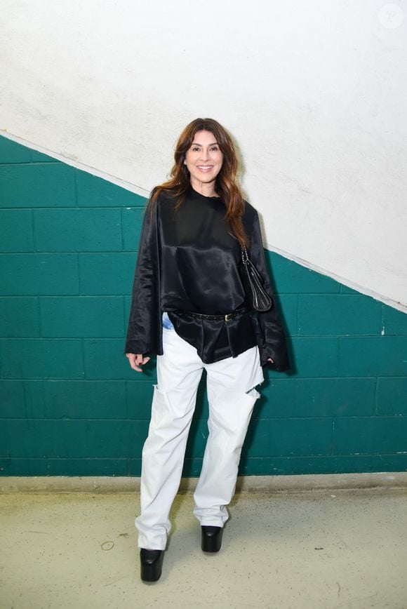 Fernanda Paes Leme: desfila um visual urbano chique e descomplicado, aliando uma blusa fluida de cetim preto com mangas longas e caimento assimétrico preso por cinto fino de couro a uma calça carpenter jeans branca de caimento amplo com recortes e puídos. O toque final fica por conta da bolsa de ombro preta e sapatos de salto com plataforma robusta