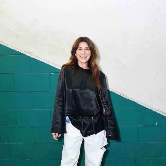 Fernanda Paes Leme: desfila um visual urbano chique e descomplicado, aliando uma blusa fluida de cetim preto com mangas longas e caimento assimétrico preso por cinto fino de couro a uma calça carpenter jeans branca de caimento amplo com recortes e puídos. O toque final fica por conta da bolsa de ombro preta e sapatos de salto com plataforma robusta