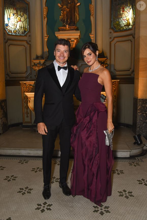 Com Rodrigo Faro, Vera Viel elegeu um vestido em tom vinho, de modelagem assimétrica e detalhe de drapeado escultural na lateral da saia