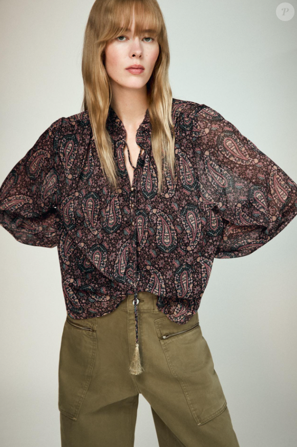 Blusa estampada boho da Zara Brasil tem transparência, custa R$ 249,00, mangas bufantes e o detalhe das franjas do fechamento com laço. Pode ser usada tanto com jeans, ou em calças com cores mais terrosas, tendências do Outono 2026.