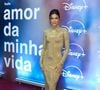 Bruna Marquezine: surge deslumbrante em um vestido longo dourado de mangas compridas, gola alta e caimento fluido todo trabalhado em brilho pontual, complementado por um penteado preso estruturado com fios soltos e maquiagem em tons neutros