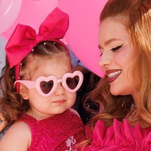 A pequena apareceu com um look digno de tapete rosa: body de paetê rosa com a palavra “Barbie” estampada, saia de tule, laço na cabeça e óculos de sol em formato de coração