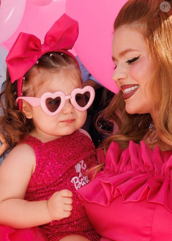 A pequena apareceu com um look digno de tapete rosa: body de paetê rosa com a palavra “Barbie” estampada, saia de tule, laço na cabeça e óculos de sol em formato de coração
