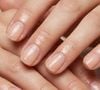 Unhas longas amendoadas, base nude e ponta branca difusa, transição cremosa estilo 'milk french', acabamento levemente glossy, iluminação natural suave, fundo branco-bege, close-up que destaque o degradê entre o nude e o branco