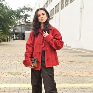 Manu Gavassi fez uma rara aparição no desfile da marca de Sasha Meneghel usando um casaco vermelho estiloso