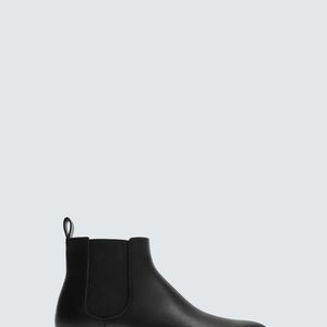 Na Zara, a bota Chelsea preta de vestir, por R$ 399,00, aparece como opção clássica e funcional, refletindo o estilo prático de Letícia Colin em 'Quem Ama, Cuida'