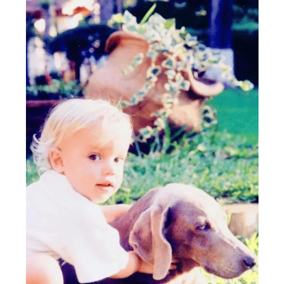 Era uma bebê bochechuda de ar angelical ao lado de sua cadela Nina.