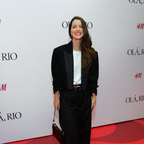 Nathalia Dill: apostando no estilo tomboy chic, a atriz surgiu em um conjunto de alfaiataria preto de corte impecável. O blazer apresenta lapelas de cetim que remetem ao clássico smoking, sobreposto a uma camiseta branca básica que traz leveza ao visual. A calça de modelagem pantalona e cintura alta foi marcada por um cinto fino com fivela dourada