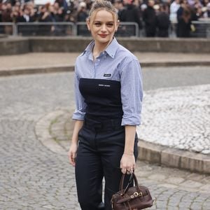 Joey King na Semana de Moda de Paris 2025: atriz marca presença no desfile da MiuMiu com look mais esporte composto por calça, camisa e bolsa além de scarpin.