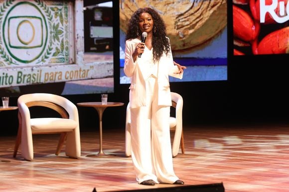A apresentadora Kenya Sade chamou a atenção no Rio2C ao adotar um terno de três peças off-white completamente alinhado com o movimento quiet luxury. Composto por um blazer estruturado, colete social abotoado e calças pantalonas fluidas de caimento perfeito, a produção exala elegância corporativa e autoridade de forma luminosa e contemporânea