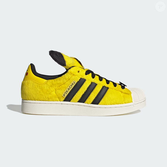 O Tênis adidas Pokémon SUPERSTAR II celebra o popular Pikachu com cabedal peludo em amarelo, rabo do personagem como pingente de cadarço e orelhas destacadas presas à língua