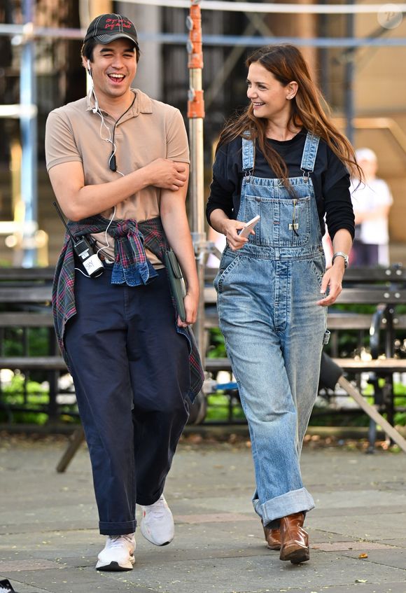 Look da atriz com barras do jeans dobradas, revelando botas de couro em tom marrom, escolha que reforça o ar despojado e prático da composição.