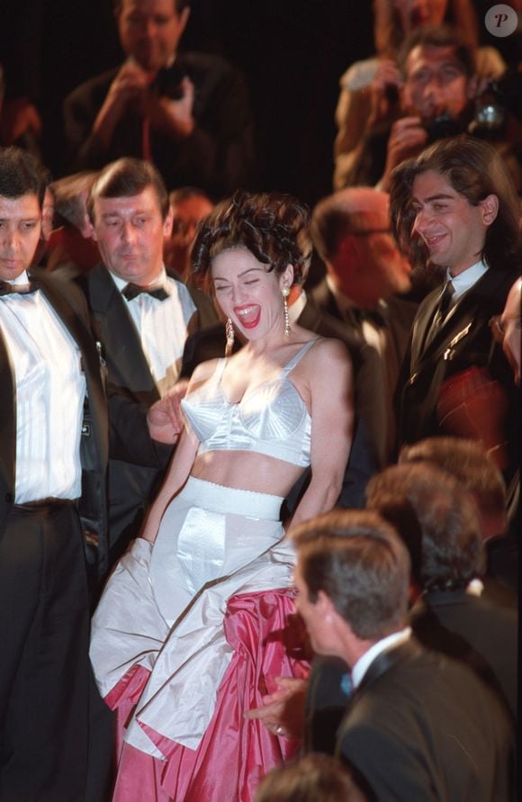 Madonna surpreendeu ao remover um robe rosa no tapete vermelho, revelando um conjunto de sutiã cônico e cinta-liga assinado por Jean Paul Gaultier em 1991